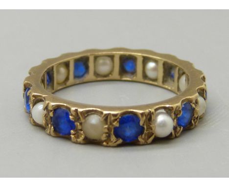 A 9ct gold, blue stone and pearl eternity ring, 2.9g, L 