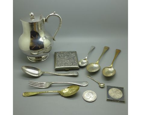 Plated ware including a jug, flatware, a cigarette box, a silver spoon, 25g, and two crowns 