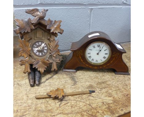 A cuckoo clock and a mantel clock, the dial marked W.H. May, Nottingham 