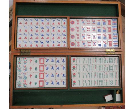 A cased mah jong set, with plastic tiles, together with a travelling backgammon game