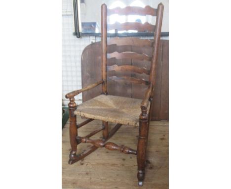 An Antique ladder back rocking chair, with rush seat