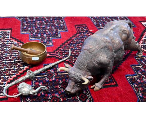 An Asian bronzed bowl-gong with wooden clapper, 10 cm diameter, to/w an Indian base-metal ornate pipe with elephant's head bo