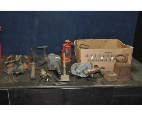 A TRAY CONTAINING VINTAGE COLLECTABLES including a 28lb weight, a 7lb weight, four irons, an iron on trivet, a Coaching lamp,