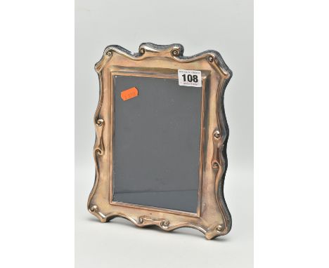 AN ELIZABETH II SILVER PHOTOGRAPH FRAME OF SCROLLED AND WAVY RECTANGULAR OUTLINE, lacks easel back, makers Carrs of Sheffield