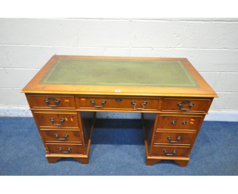 A 20TH CENTURY YEW WOOD TWIN PEDESTAL DESK, with green tooled leather writing surface, fitted with eight drawers, on bracket 