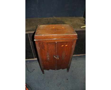 A VINTAGE VALVE RADIO IN A LIDDED OAK CABINET with a battery inside width 54cm depth 35cm height 91cm (untested)(Condition Re