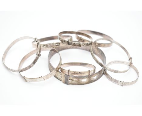 A SELECTION OF MAINLY CHILD'S SILVER AND WHITE METAL BANGLES, to include eight expandable child's bangles and a belt design b