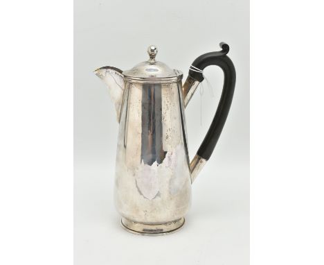 A GEORGE V SILVER WATER JUG, polished form, fitted with an ebonised handle, hinged cover fitted with a ball finial, hallmarke