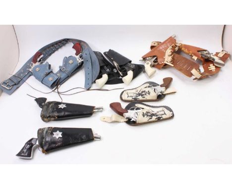 A collection of leather and plastic 1950s and later cowboy cap guns, pistols and holsters to include a Hubley cowboy pair of 