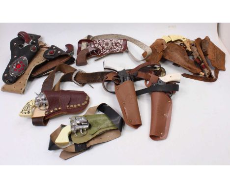 A collection of leather and plastic 1950s and later cowboy holsters with pistols to include a pair of Frontier 45 pistols wit