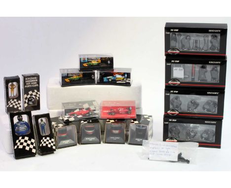 A collection of mixed scale 1/18, 1/64 and 1/43 Minichamps display helmets, pit crews, and racing cars, including an Eddie Ir