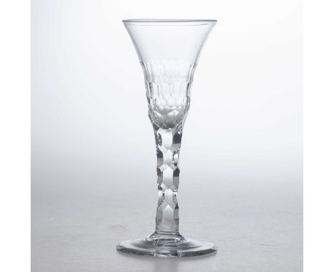 A RARE 18TH CENTURY WINE GLASS the flared trumpet bowl half panel cut, raised on a facet cut stem and conical foot facet cut 