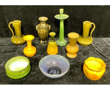 A pair of Arts &amp; Crafts long necked jugs, in olive glaze, scroll handles, 27cm high; a Barnstable Pottery candlestick, 40