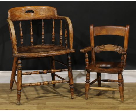 An early 20th century oak elbow chair, 76cm high, 55cm wide, the seat 46cm, wide and 44cm deep; a child’s commode chair, 59.5