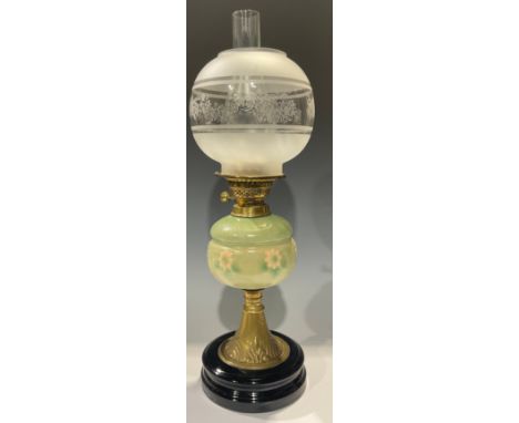A late 19th century oil lamp, embossed brass column, ceramic reservoir moulded with flowers heads, twin burner, acid etched g