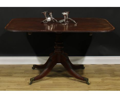 A Post-Regency tulipwood crossbanded mahogany centre table, rounded rectangular tilting top, turned column, reeded sabre legs