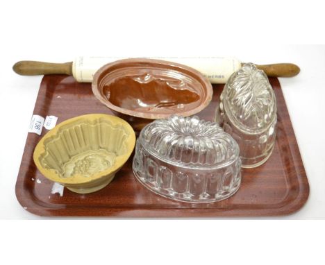Four 19th century moulds, two glass and two ceramic, one in the form of a rabbit, together with a ceramic advertising rolling