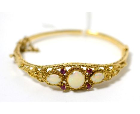 A 9 carat gold opal and ruby bangle 16.38g gross