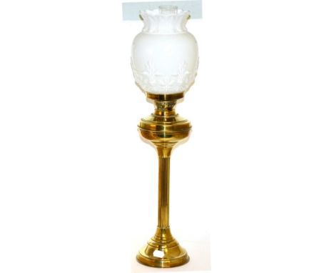 A brass column oil lamp with a milk glass coloured shade 