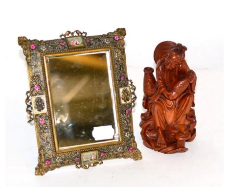 A Chinese carved hardwood figure of a fisherman and a paste set gilt metal framed small easel back mirror (2) 