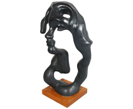 A abstract sculpture of a face, composite patinated material, on wooden base, overall height 56cm 