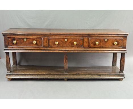 AN EARLY 18TH CENTURY OAK DRESSER, the moulded edge above three short drawers with replacement knob handles and stamped lock 