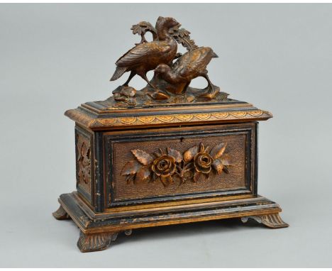 A LATE 19TH CENTURY BLACK FOREST TEA CADDY, or rectangular form, the hinged cover carved with two game birds amongst foliage,