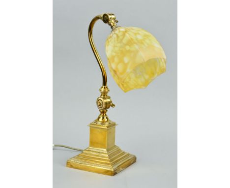 AN EARLY 20TH CENTURY BRASS DESK LAMP, mottled yellow and white hexagonal glass shade, on an adjustable scrolled arm, short s