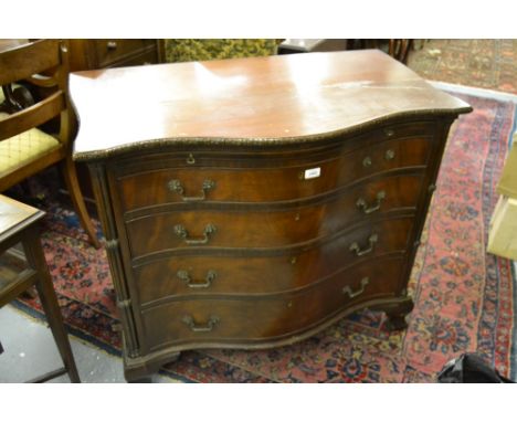 Early 20th Century mahogany serpentine shaped chest, the moulded top with a brushing slide above four graduated drawers with 