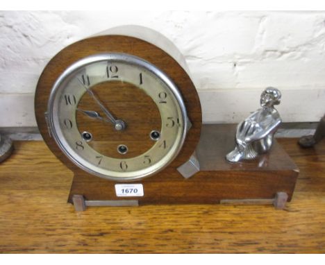1920's Mahogany mantel clock mounted with a chrome figure of a seated girl with circular dial having Arabic numerals and thre