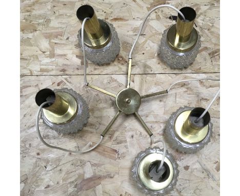 A five arm drop ceiling light with brass fittings and textured glass shades