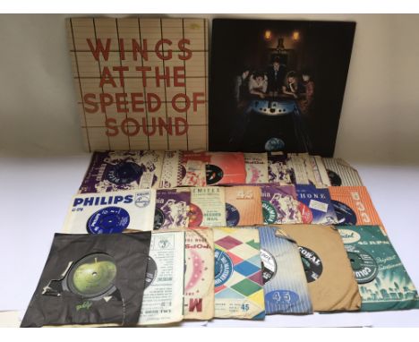 A collection of 7 inch singles by various artists including The Beatles, The Rolling Stones and others plus two Wings LPs.