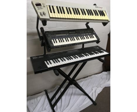 A Yamaha DJX II keyboard, a Casio CZ 101 keyboard, a Midi composer keyboard and a triple keyboard stand.