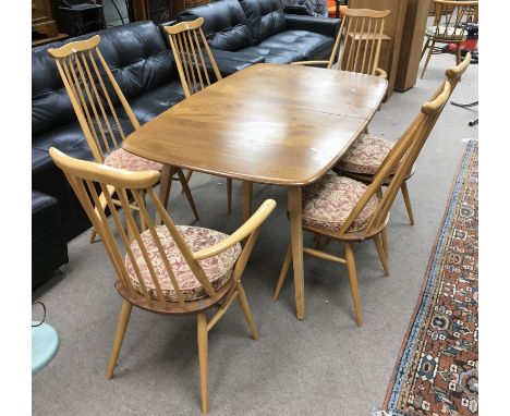 An Ercol light wood extending table and six matching Windsor chairs including two carvers