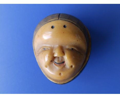 A Japanese signed nut mask netsuke.