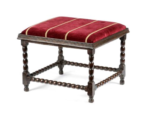 A QUEEN ANNE OAK STOOLC.1710with bobbin turned decoration, the rectangular drop-in seat inside a moulded frame on turned and 