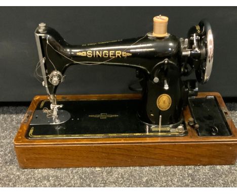 A vintage Singer electric sewing machine, no EH222540, oak case.