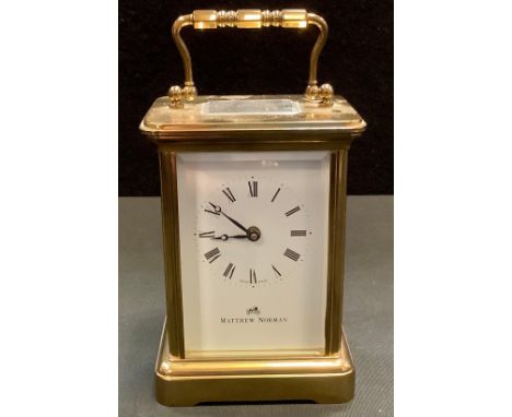 A carriage clock by Matthew Norman, with white enamel dial with Roman numerals and makers name, the brass four glass case wit