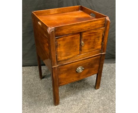 A George III mahogany tray top commode, pierced handles above a pair of cupboard doors and a drawer-commode, chamfered square
