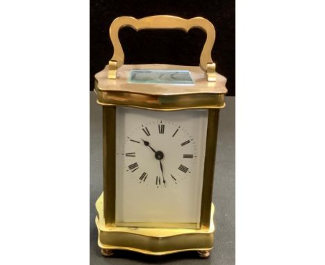 A brass carriage clock, serpentine brass body, Roman numerals. 16cm high. 