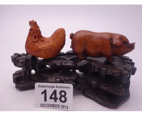 Carved Netsuke style Pig, carved Netsuke style Chicken and a hardwood Japanese stand 