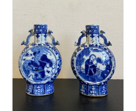A near pair of possibly 19th century blue and white Chinese moon flasks each having a cylindrical funnel neck flanked by a pa