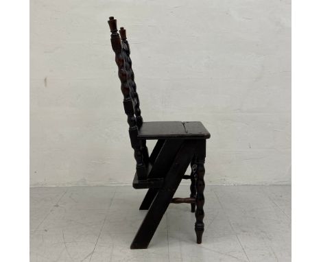 A C.1900 oak metamorphic library chair having a  turned and carved back with a spindled splat over a square plank seat hinged