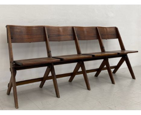An early 20th century oak folding four seat chapel bench having a curved top rail over four shaped saddle seats raised on fla