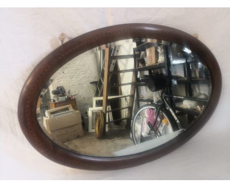 An Edwardian mahogany wall mirror having an oval plate in an ebony and satinwood inlaid surround. 65X42cm 
