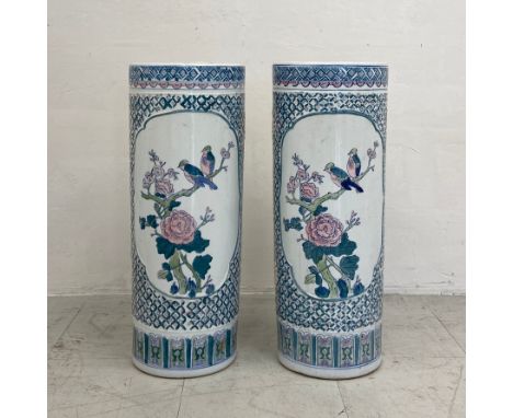 A pair of contemporary Chinese umbrella stands each of cylindrical form with figural vignettes depicting birds among foliage 