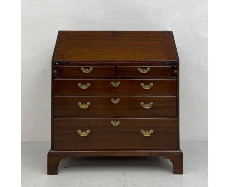 A Georgian mahogany bureau having a fall front with a gilt and tooled red leather lined slope with a fitted interior over an 