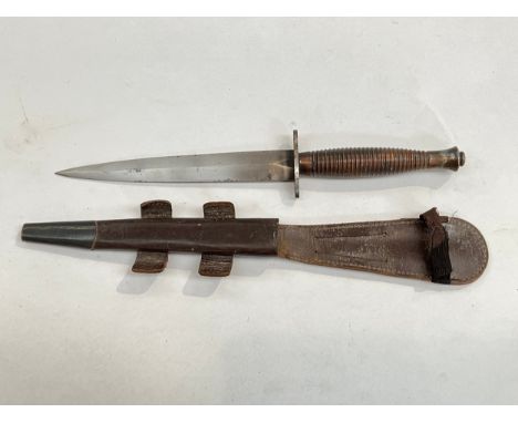 A Fairbairn Sykes third pattern commando dagger, with scabbard, the guard marked with broad arrow 