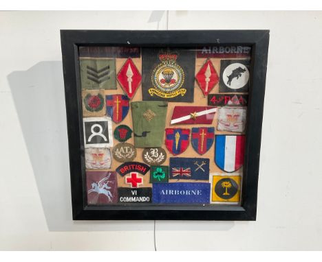 A framed display of military cloth badges including RASC, Anti Tank Gunner patch badge, 16th Air Assault etc 