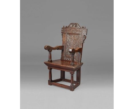 A documented and good James I oak panel-back open armchair, circa 1620  The rectangular back panel carved with a floral bouqu